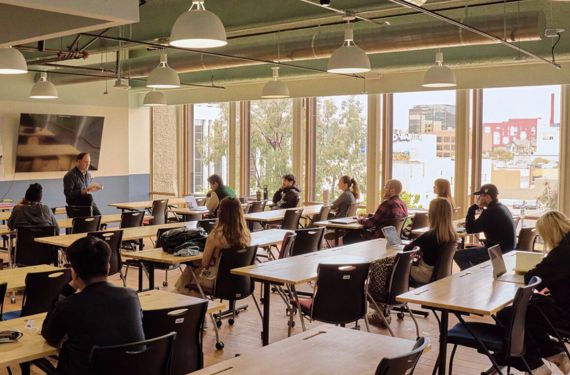 NewSchool professor at the front of the classroom lecturing to students