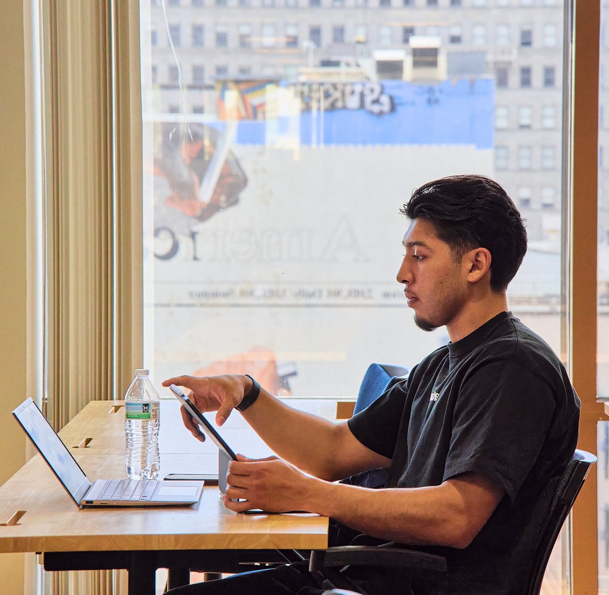 A student using a tablet at his desk in a NewSchool classroom