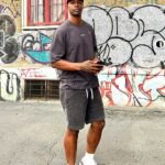 Shawn standing in front of a graffiti wall.