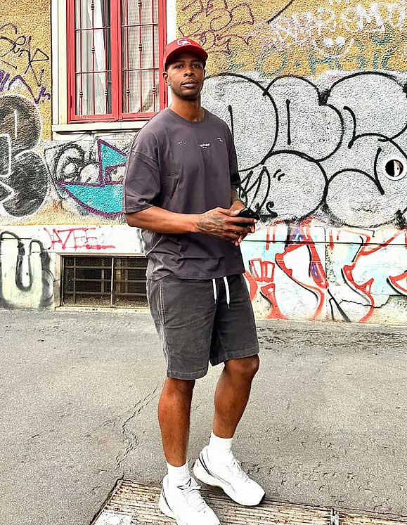 Shawn standing in front of a graffiti wall.