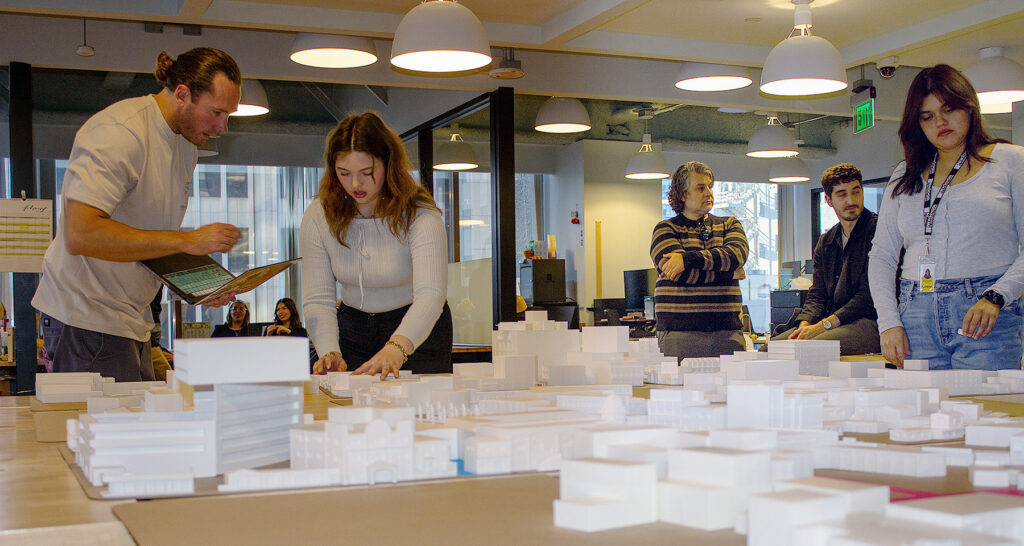 Architecture Students working on their model, while their professor looks on