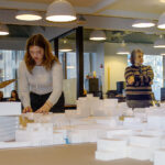 Architecture Students working on their model, while their professor looks on