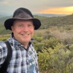 Fred Besancon smiling in a field at sunset